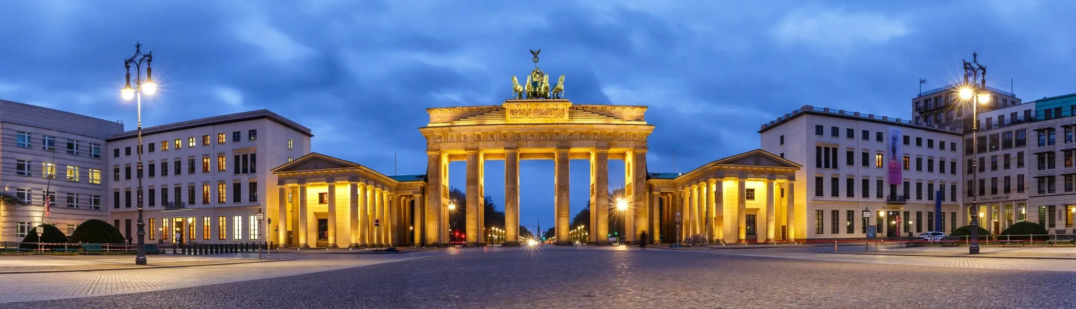 Foto des beleuchteten Brandenburger Tors bei Abenddämmerung in Berlin, Deutschland.